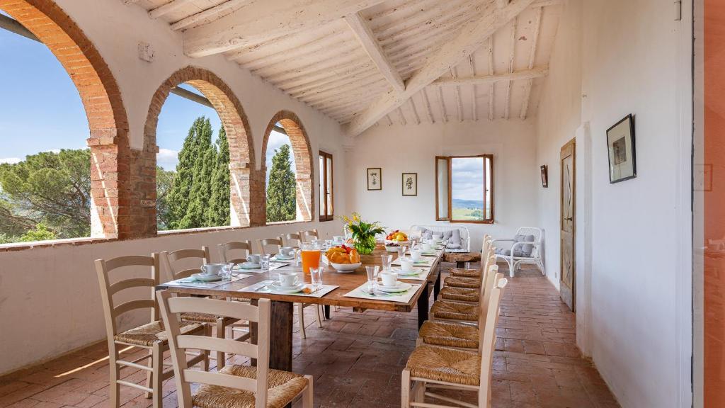 une salle à manger avec une longue table et des chaises dans l'établissement CASALE RASA 20&2, Emma Villas, à Asciano