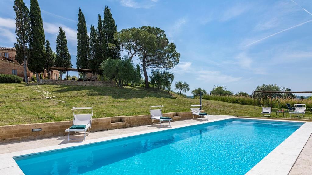 - une piscine avec 2 chaises et une cour dans l'établissement CASALE RASA 20&2, Emma Villas, à Asciano