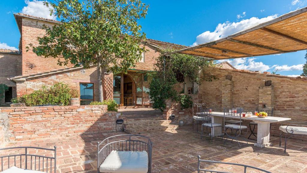 un patio extérieur avec une table et des chaises dans l'établissement CASALE RASA 20&2, Emma Villas, à Asciano