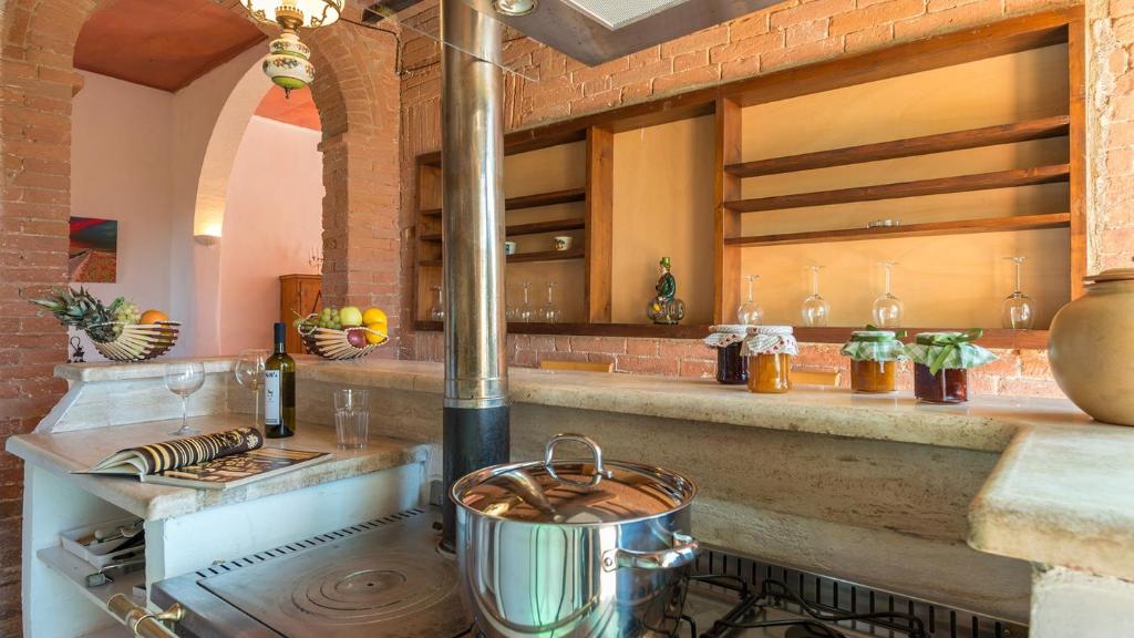 - une cuisine avec cuisinière et pot dans l'établissement CASALE RASA 20&2, Emma Villas, à Asciano