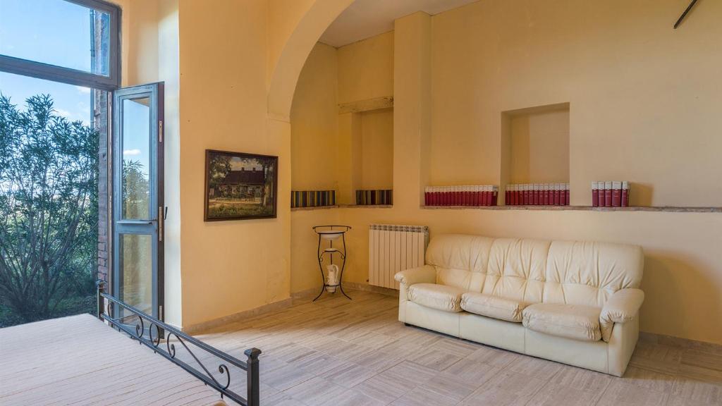 un salon avec un canapé et une grande fenêtre dans l'établissement CASALE RASA 20&2, Emma Villas, à Asciano