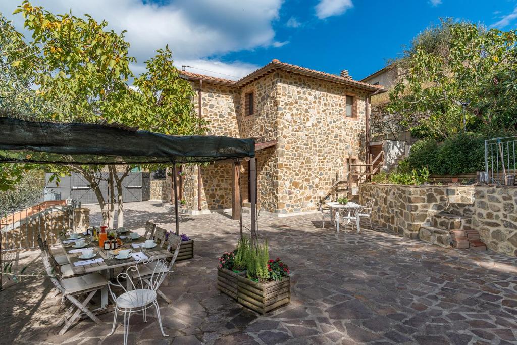 un patio avec une table et des chaises et un bâtiment dans l'établissement CASALE MONTEGIOVI 6, Emma Villas, à Montegiovi