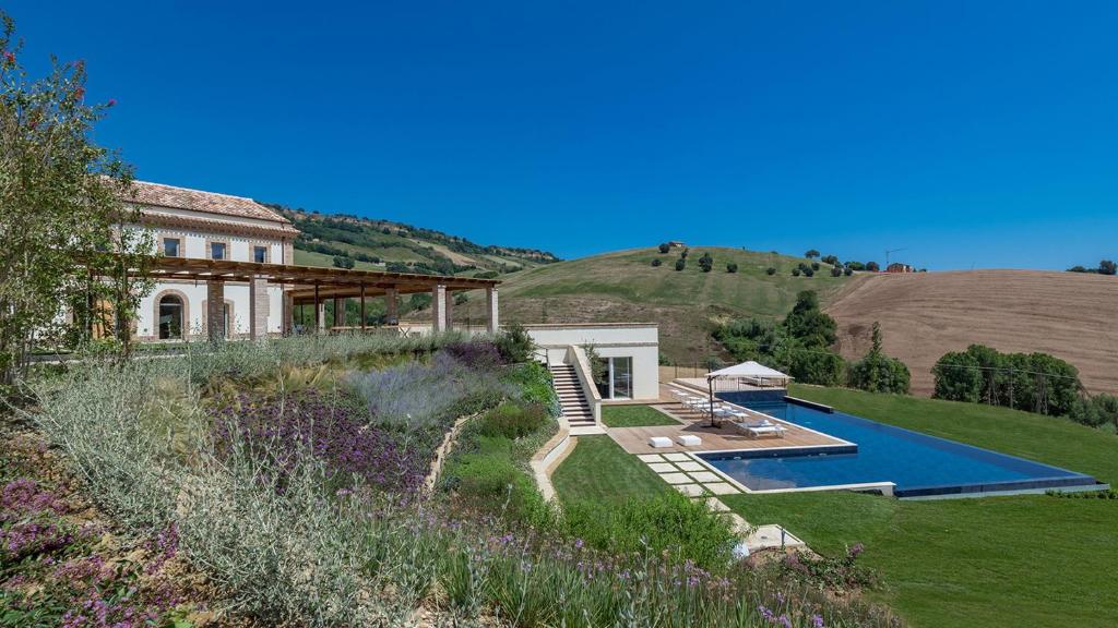 une maison avec une piscine dans une cour dans l'établissement Dimora Montefiore 11, Emma Villas, à Montefiore dellʼAso