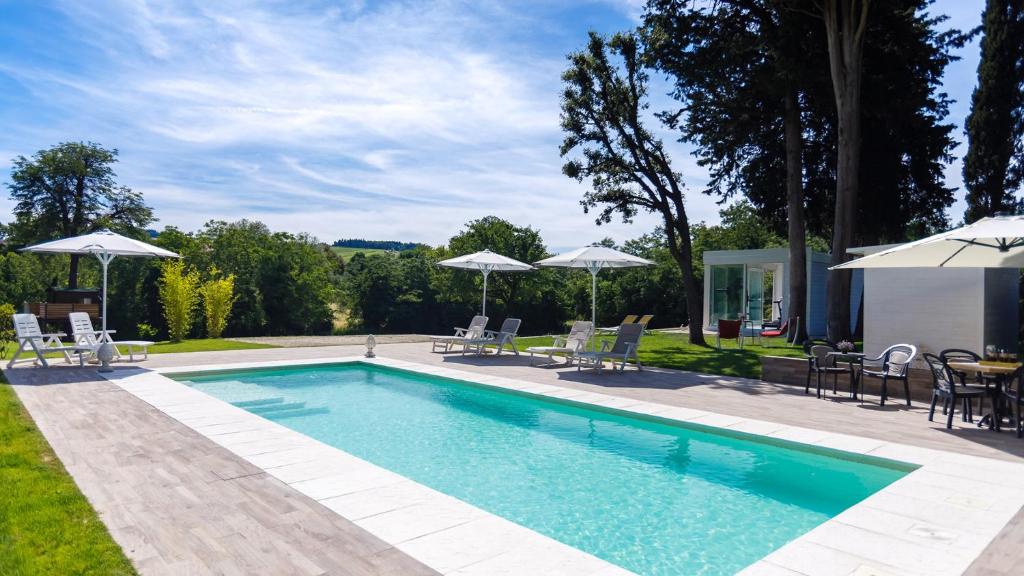 une piscine avec chaises, tables et parasols dans l'établissement La Casa Di Nanì 8, Emma Villas, à Forlì