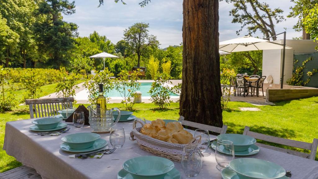 - une table avec des assiettes et un panier de pain dans l'établissement La Casa Di Nanì 8, Emma Villas, à Forlì