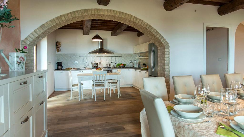une cuisine et une salle à manger avec une table et des chaises dans l'établissement La Vecchia Fonte 15, Emma Villas, à Volterra