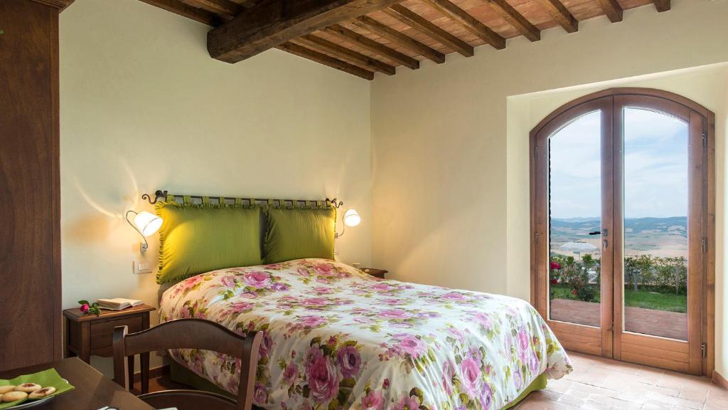 une chambre avec un lit et une grande fenêtre dans l'établissement La Vecchia Fonte 15, Emma Villas, à Volterra