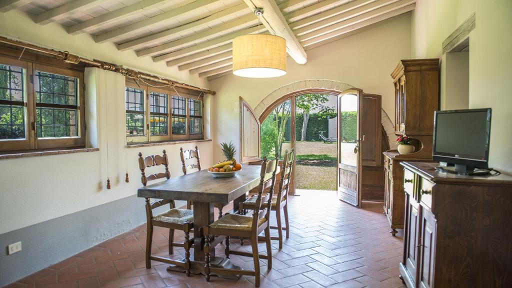 une salle à manger avec une table et des chaises en bois dans l'établissement Le Caselle 26, Emma Villas, à Cortone