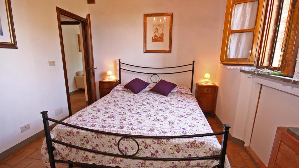 - une chambre avec un lit et des oreillers violets dans l'établissement Monterzi 4, Emma Villas, à San Giovanni dʼAsso