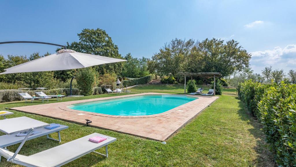 une piscine dans une cour avec un parasol dans l'établissement PODERE DI SALCI 10, Emma Villas, à Città della Pieve