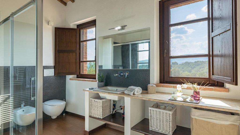 une salle de bain avec un lavabo, des toilettes et un miroir dans l'établissement PODERE DI SALCI 10, Emma Villas, à Città della Pieve