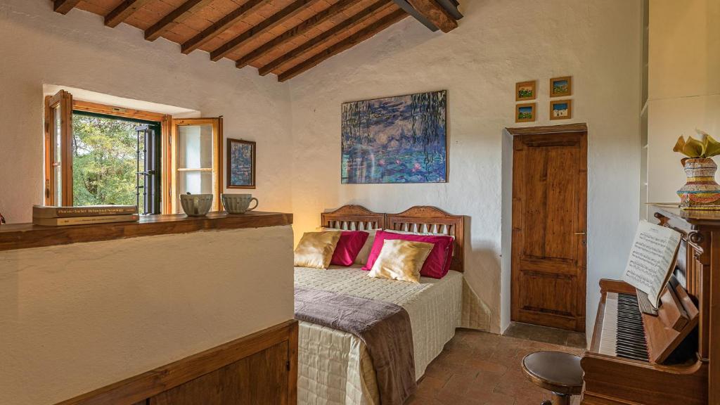 une chambre avec un lit avec des oreillers rouges et une fenêtre dans l'établissement PODERINO 6, Emma Villas, à Trequanda