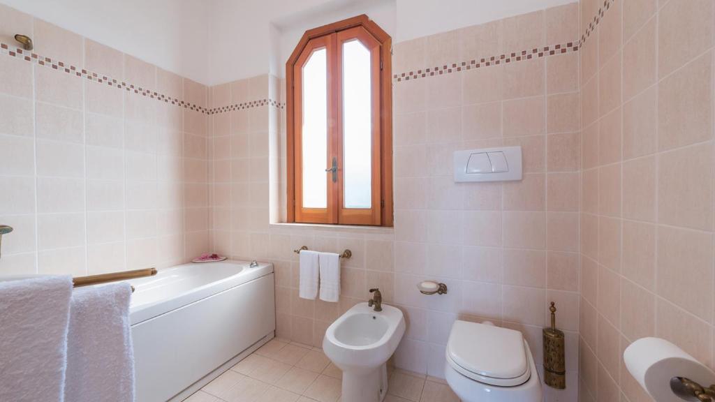 une salle de bain blanche avec toilettes et lavabo dans l'établissement RIPARI DI GIOBBE 6&2, Emma Villas, à Ortona