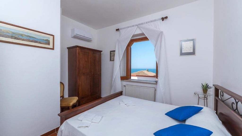 une chambre avec un lit et une fenêtre avec l'océan dans l'établissement RIPARI DI GIOBBE 6&2, Emma Villas, à Ortona