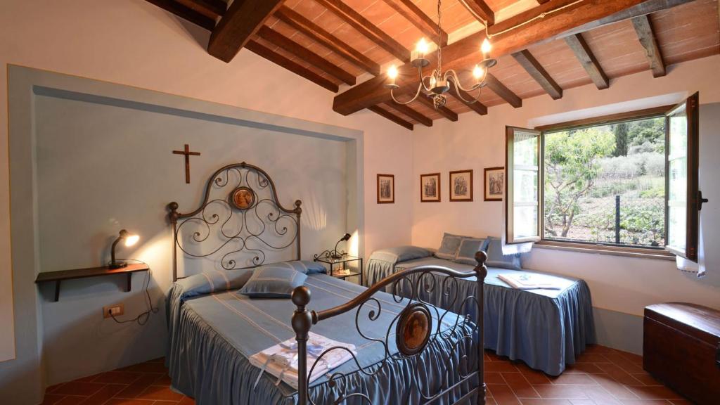 - une chambre avec 2 lits et une croix sur le mur dans l'établissement Sferracavalli 4, Emma Villas, à Sarteano