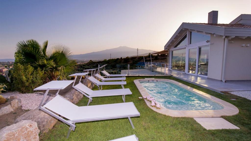 une maison avec une piscine et un groupe de chaises dans l'établissement Villa Aura 6, Emma Villas, à Giardini Naxos