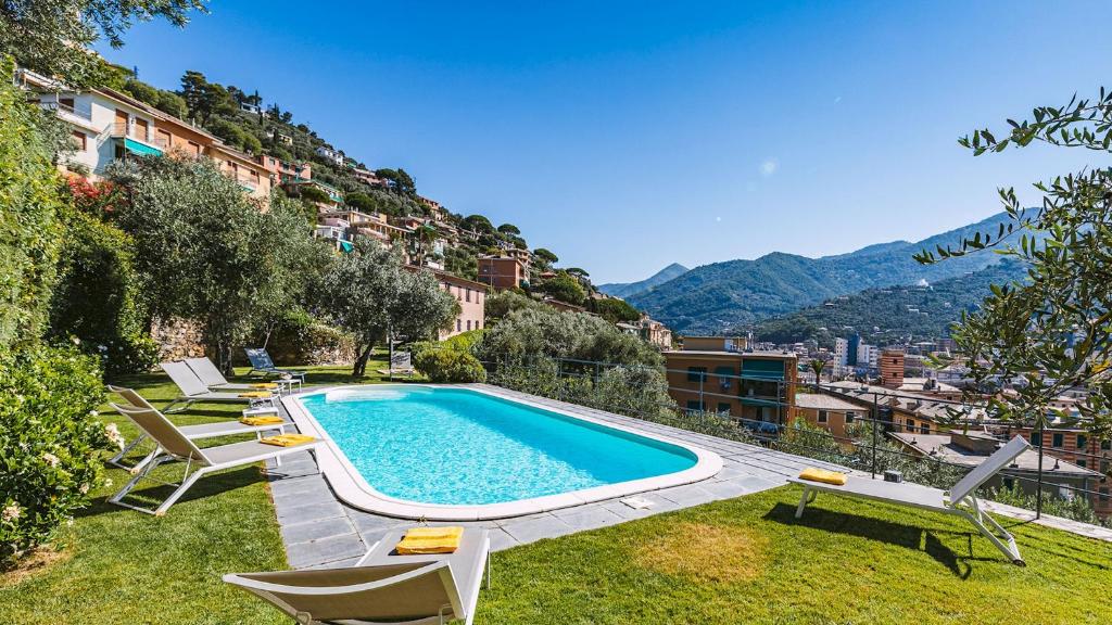 une piscine avec des chaises longues à côté d'un bâtiment dans l'établissement Villa Baia Blu 12, Emma Villas, à Camogli