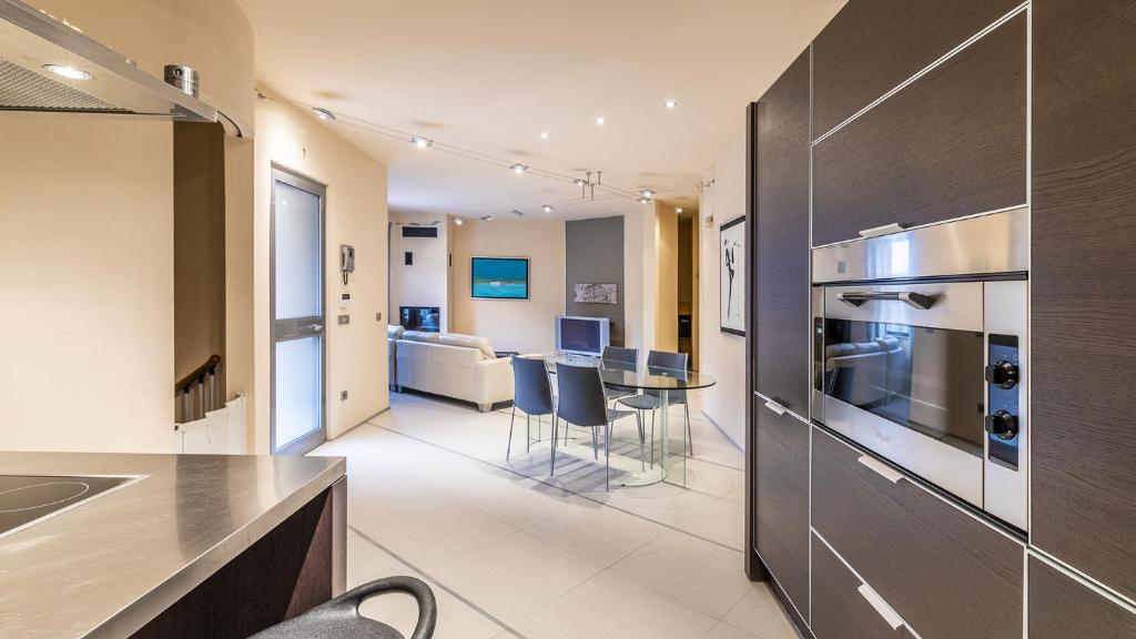 Il comprend une cuisine et un salon avec une cuisinière et une table. dans l'établissement VILLA ELDA 6, Emma Villas, à Loano