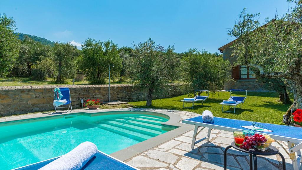 - une piscine dans une cour avec des chaises et une table dans l'établissement VILLA FABI 6&2, Emma Villas, à Cortone