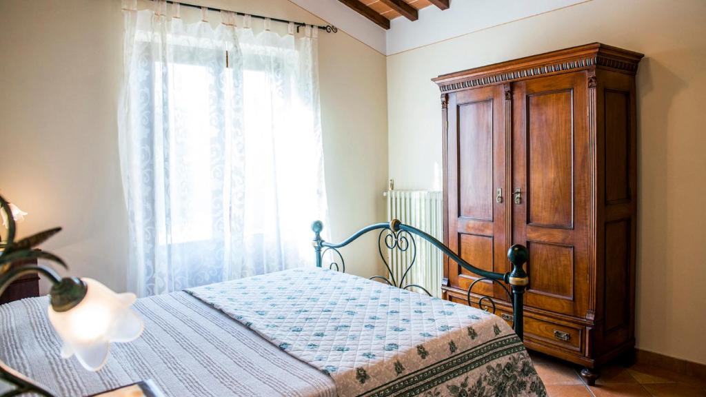 une chambre avec un lit et une armoire en bois dans l'établissement Vinciluna 4, Emma Villas, à Cortone 29 autres photos