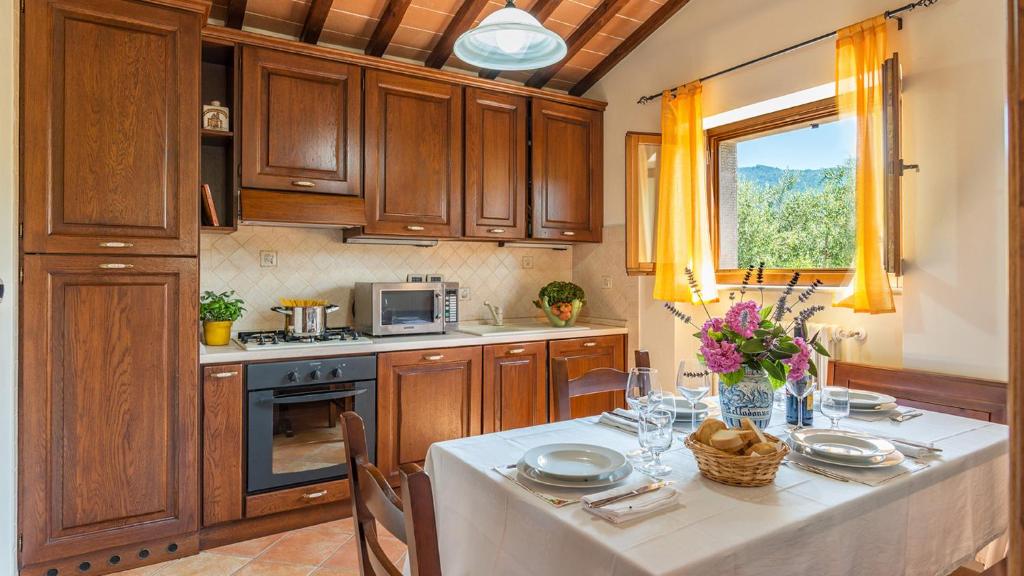 une cuisine avec une table et un chiffon de table blanc dans l'établissement Vinciluna 4, Emma Villas, à Cortone