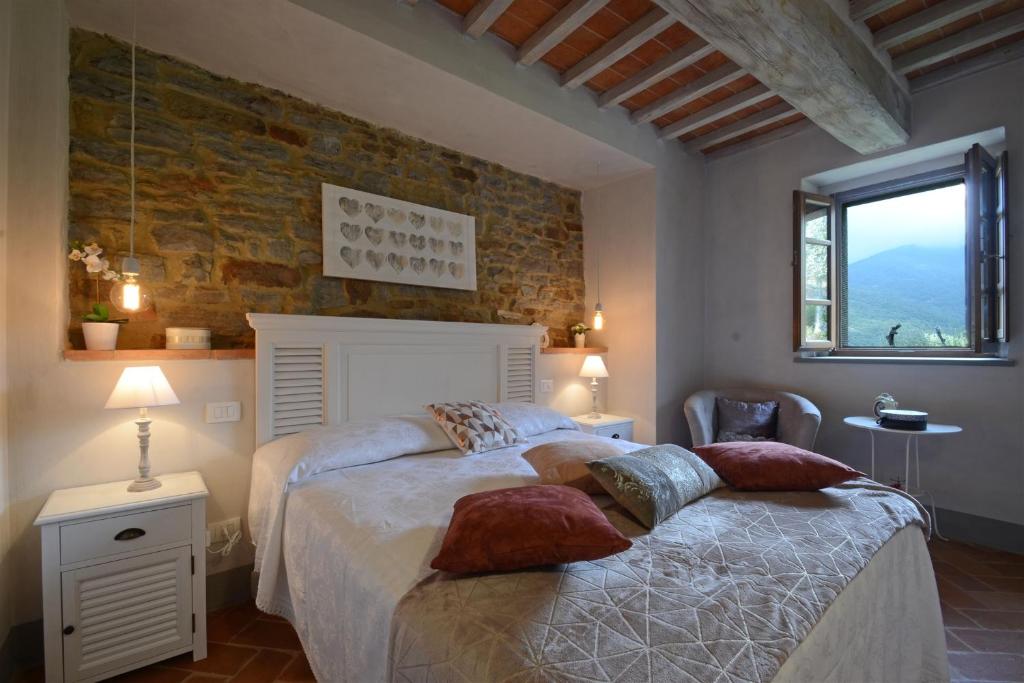 une chambre avec deux lits et un mur de briques dans l'établissement Torre La Ripa 8, Emma Villas, à Cortone 43 autres photos