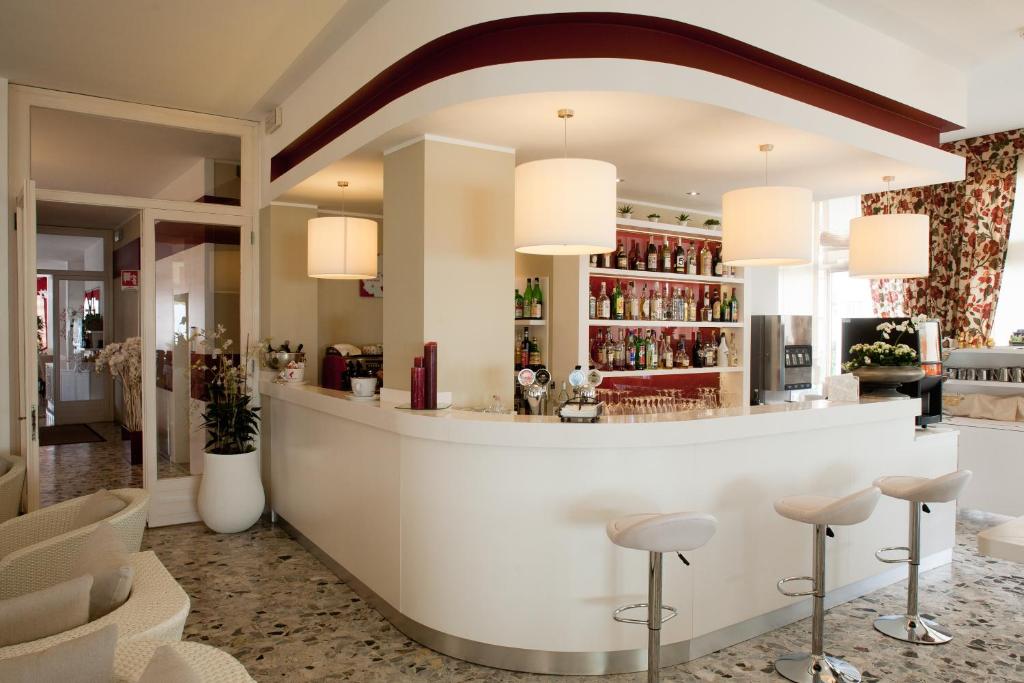 un bar dans le hall d'un hôtel avec des tabourets dans l'établissement Hotel Canarie, à Lido di Jesolo