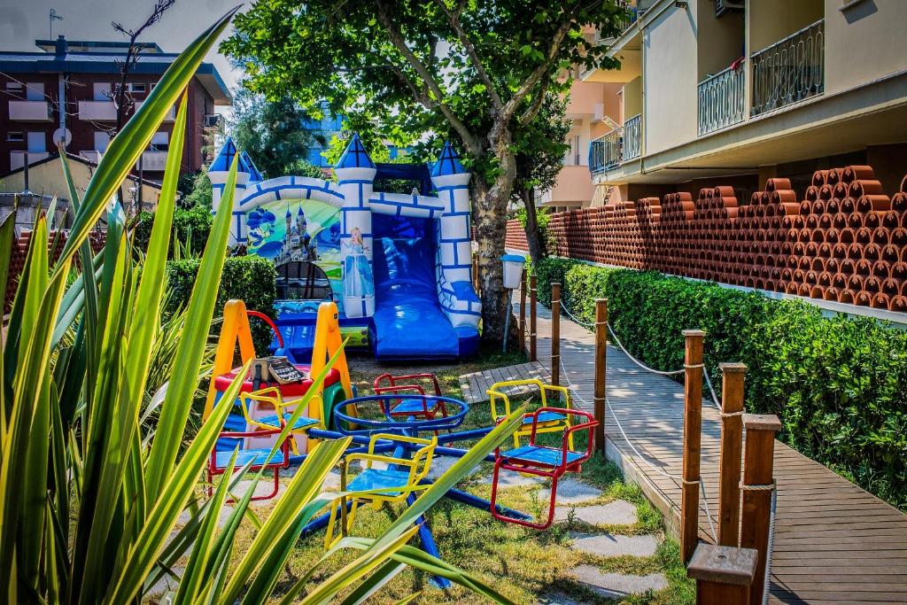 - une aire de jeux avec des chaises colorées et un toboggan dans l'établissement Hotel Rosalba - Valentini Family Village, à Bellaria-Igea Marina