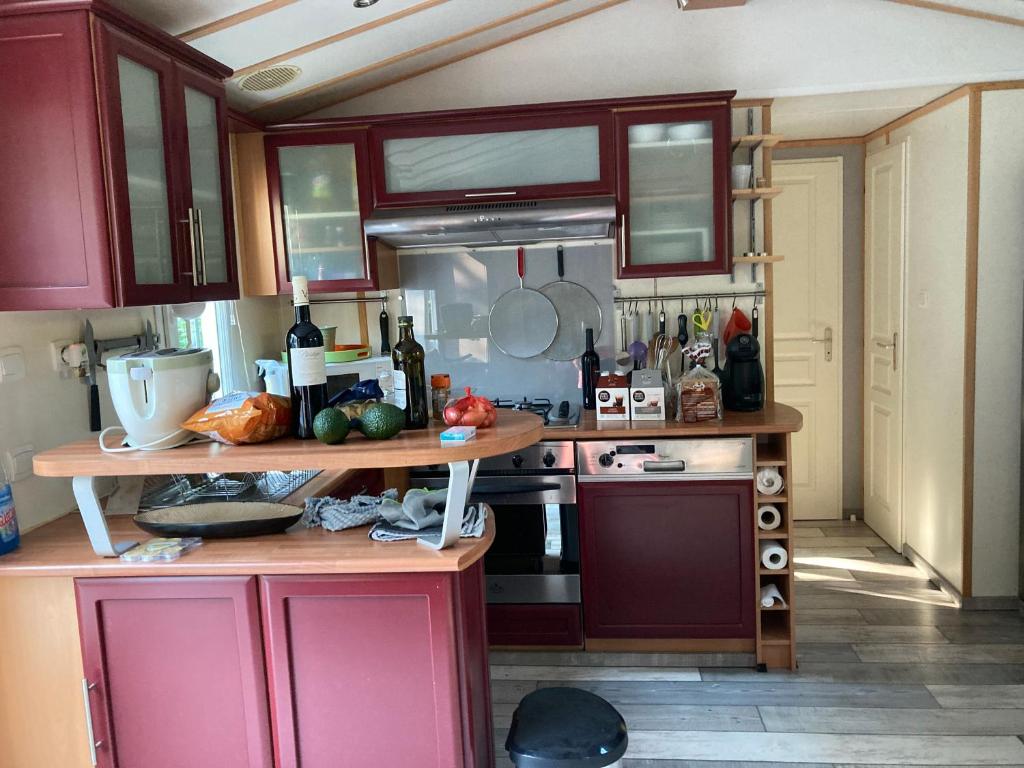 une cuisine avec des armoires rouges et un comptoir dans l'établissement Mobil Home Golf de Saint Tropez, à La Garde-Freinet