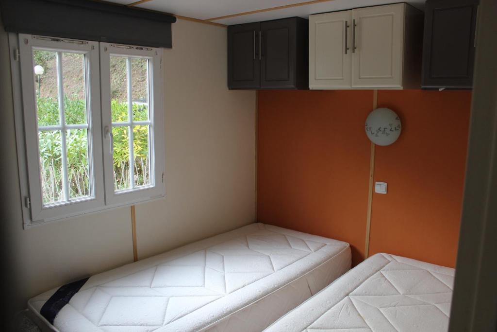 Cette petite chambre dispose de deux fenêtres et d'un canapé. dans l'établissement Mobil Home Golf de Saint Tropez, à La Garde-Freinet 22 autres photos