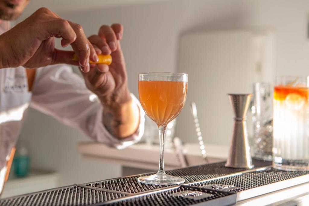 une personne tenant un fruit à côté d'un verre de vin dans l'établissement Hotel Vista di Capri, à Massa Lubrense 37 autres photos