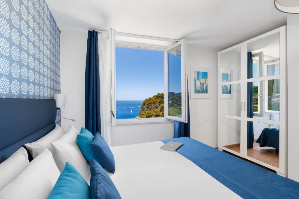 une chambre avec un grand lit et une grande fenêtre dans l'établissement Hotel Vista di Capri, à Massa Lubrense