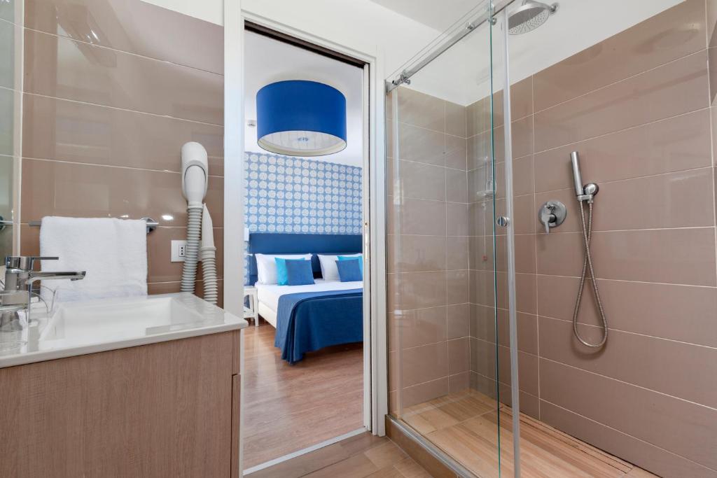 Cette chambre comprend un lit et une salle de bains pourvue d'une douche. dans l'établissement Hotel Vista di Capri, à Massa Lubrense