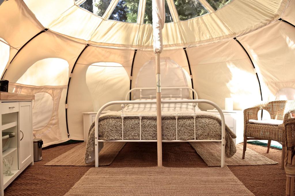 - un lit dans une tente dans une chambre dans l'établissement Glamping at Camping La Source, à Saint-Pierre-dʼArgençon