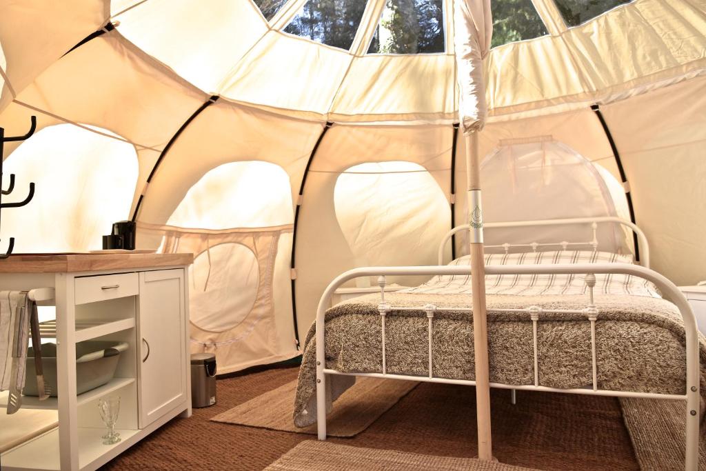 une chambre avec un lit dans une tente dans l'établissement Glamping at Camping La Source, à Saint-Pierre-dʼArgençon