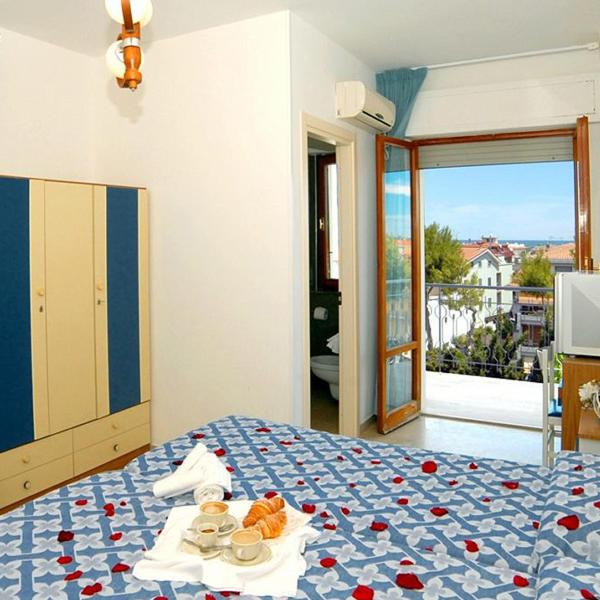 - une chambre dotée d'un lit avec des assiettes de nourriture dans l'établissement Hotel President, à San Benedetto del Tronto