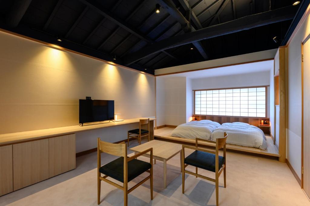 une chambre avec un lit, une table et des chaises dans l'établissement Kappo Ryokan Yumesaki, à Beppu 37 autres photos