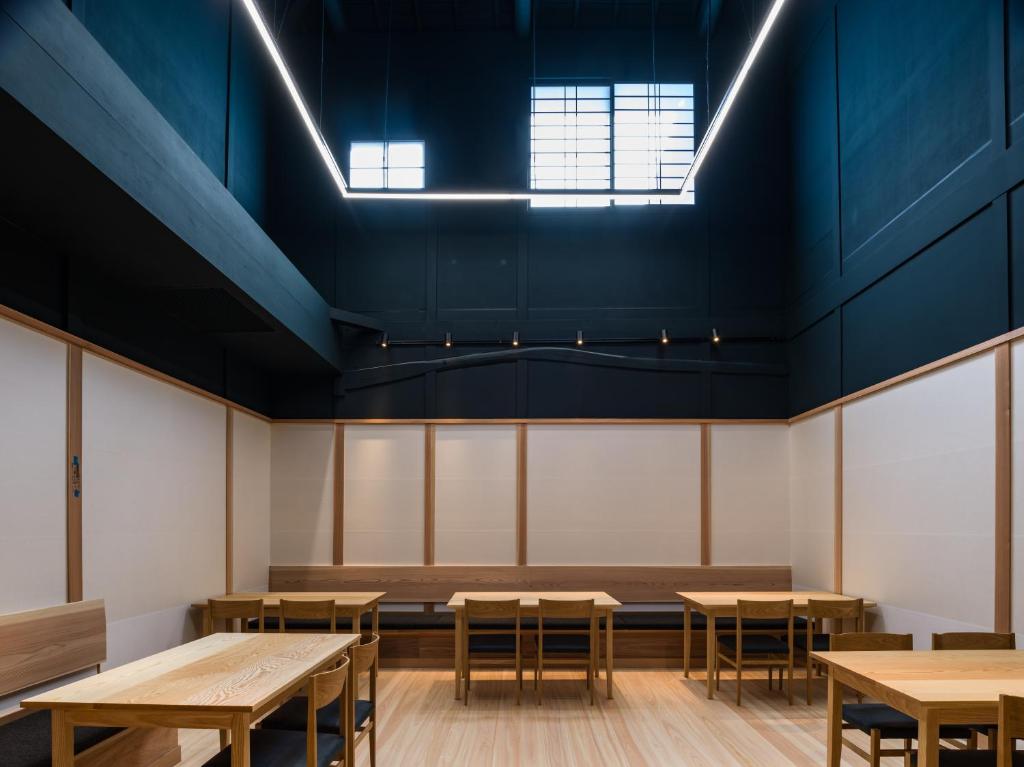 une pièce vide avec tables et bancs dans l'établissement Kappo Ryokan Yumesaki, à Beppu