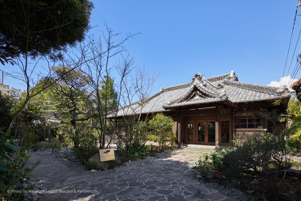 un bâtiment avec une enseigne devant lui dans l'établissement LOQUAT西伊豆, à Izu