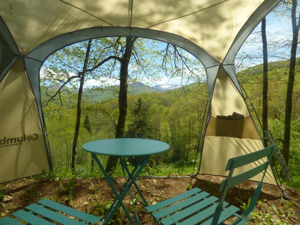 - une table et des chaises dans une tente avec vue dans l'établissement D'tente sky lodge, à Massat
