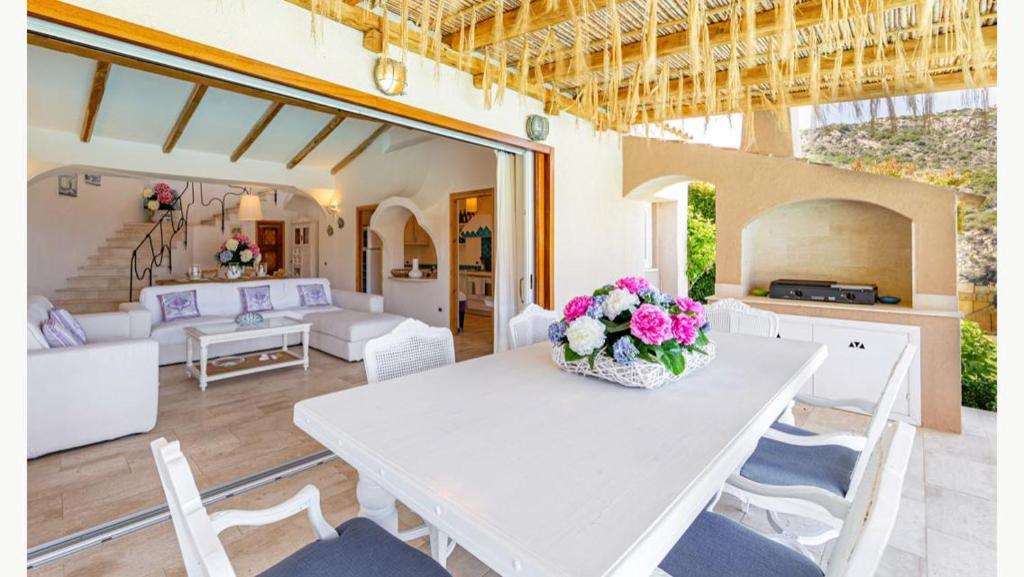 - une table blanche avec des fleurs dans le salon dans l'établissement Sardinia Family Villas - Villa MariaPia with private pool and seaview, à Porto Cervo