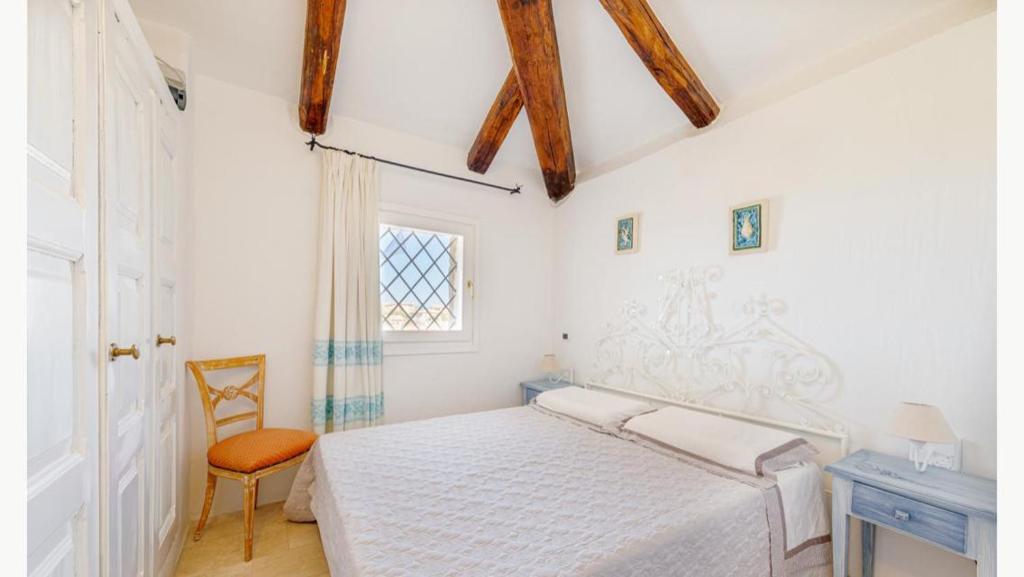 une chambre blanche avec un lit et une chaise dans l'établissement Sardinia Family Villas - Villa MariaPia with private pool and seaview, à Porto Cervo 27 autres photos