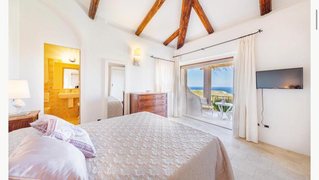 une chambre avec un lit et une vue sur l'océan dans l'établissement Sardinia Family Villas - Villa MariaPia with private pool and seaview, à Porto Cervo