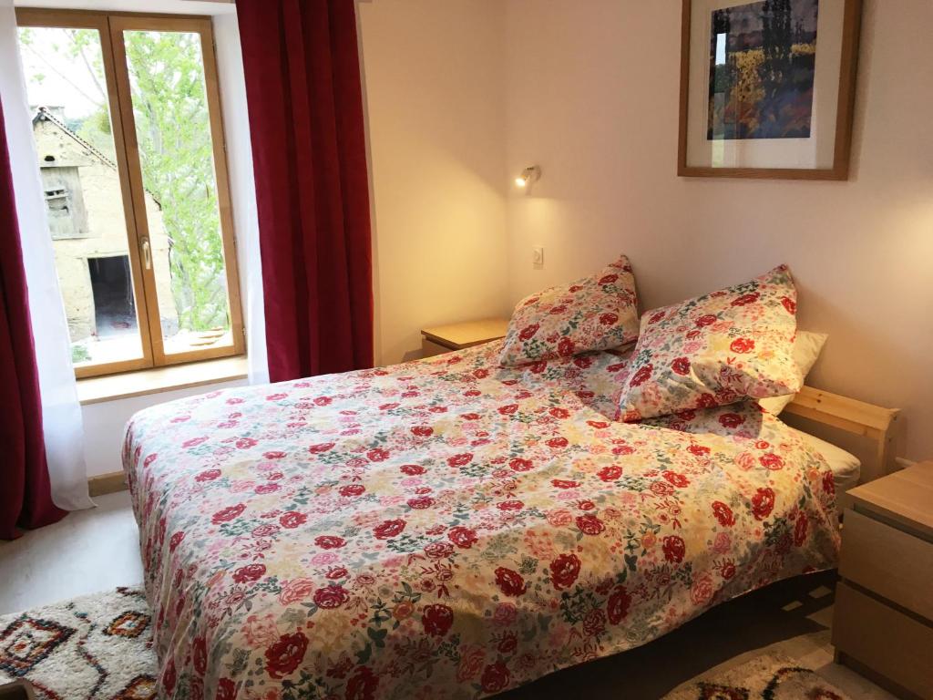 - une chambre avec un lit avec une couette à fleurs et une fenêtre dans l'établissement Les Maricotais Gîte L'Hirondelle, à Trévérien 20 autres photos