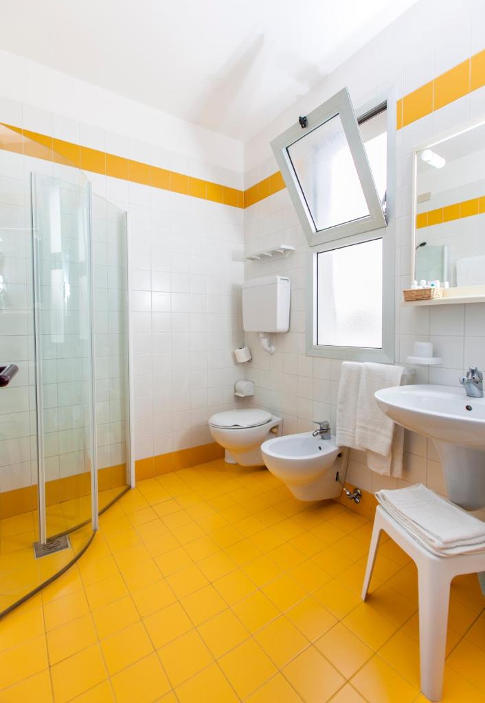 une salle de bain avec deux toilettes et un lavabo dans l'établissement Hotel Wally, à Lido di Jesolo