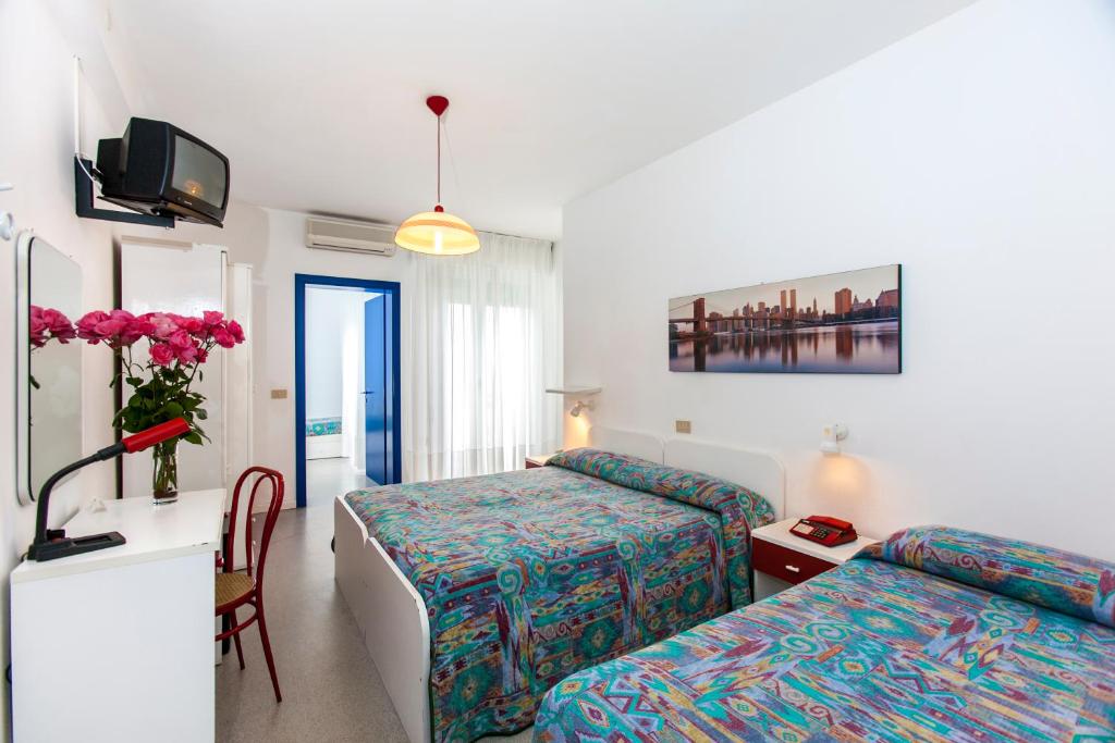 une chambre d'hôtel avec deux lits et un bureau dans l'établissement Hotel Wally, à Lido di Jesolo