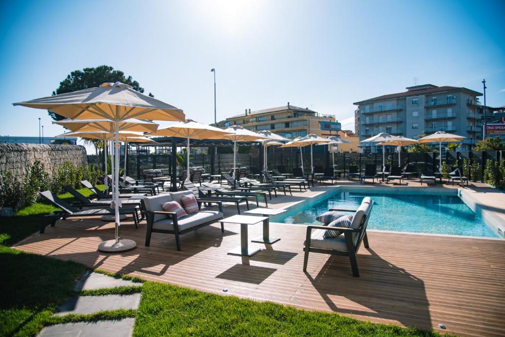 une piscine avec chaises, tables et parasols dans l'établissement Modica Boutique Hotel, à Modica