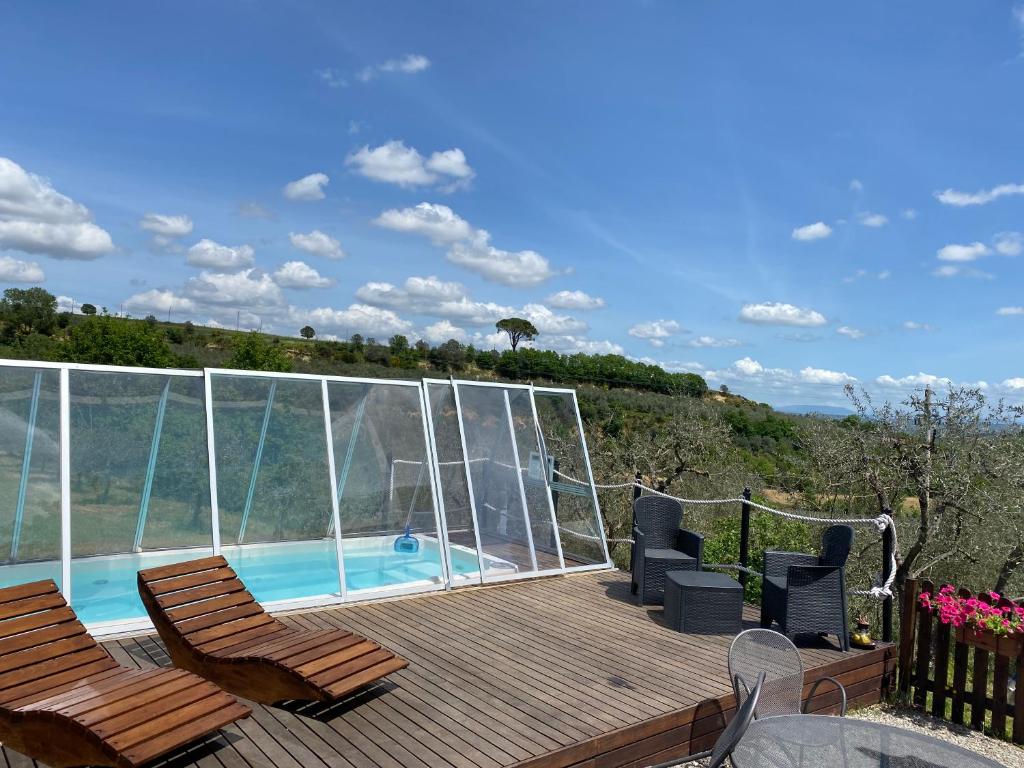 une terrasse avec deux chaises et une piscine dans l'établissement Villetta Toscana - Montepulciano, à Montepulciano