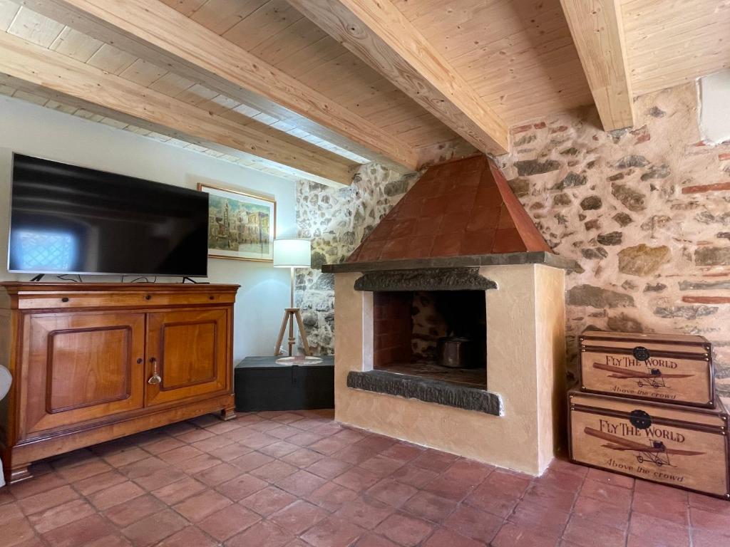 Il comprend un salon doté d'une cheminée en pierre et d'une télévision à écran plat. dans l'établissement ShaLeo Holiday Home, à Marliana