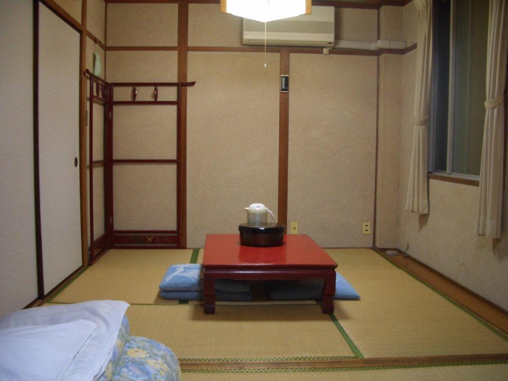 une chambre avec une table au milieu d'une pièce dans l'établissement Kasuga Ryokan, à Hiroshima